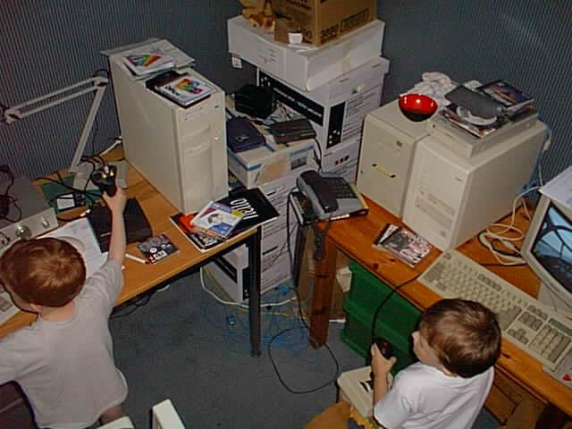 2 young boys playing a networked air combat game surrounded by sundry hardware as described in main post